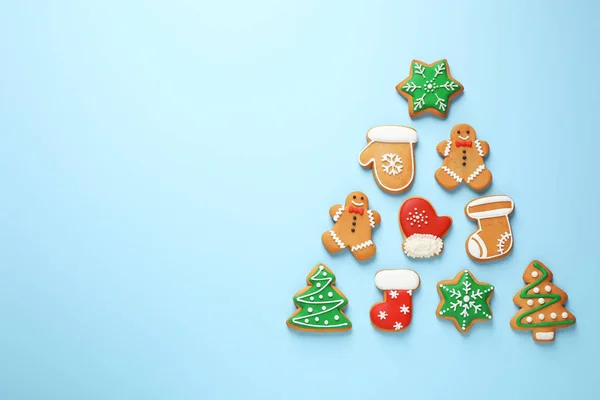 Forma de árvore de Natal feito de biscoitos caseiros saborosos no fundo azul claro, flat lay. Espaço para texto — Fotografia de Stock