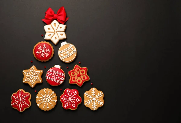 Forma de árvore de Natal feito de biscoitos caseiros saborosos no fundo preto, flat lay. Espaço para texto — Fotografia de Stock