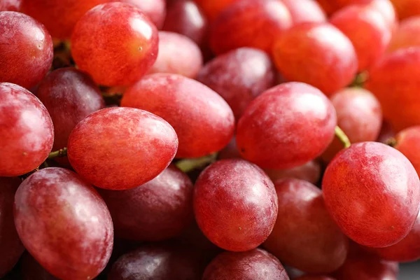 Fresh ripe juicy pink grapes as background, closeup view — Stock Photo, Image