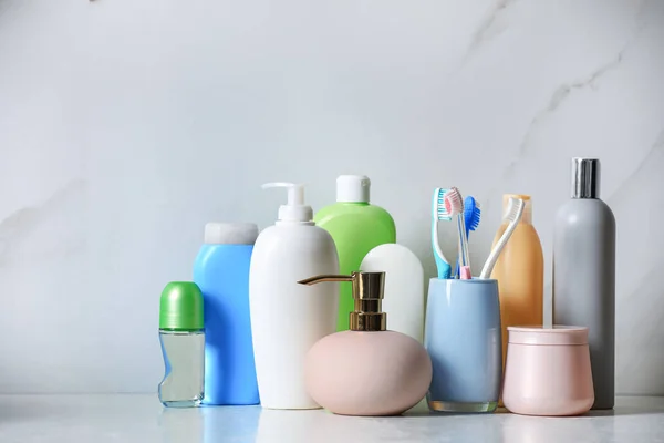 Desodorizante roll-on e produtos de higiene pessoal diferentes na mesa de mármore perto da parede clara — Fotografia de Stock
