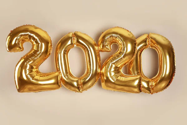 Golden balloons for party decoration on beige background. 2020 New Year celebration — Stock Photo, Image
