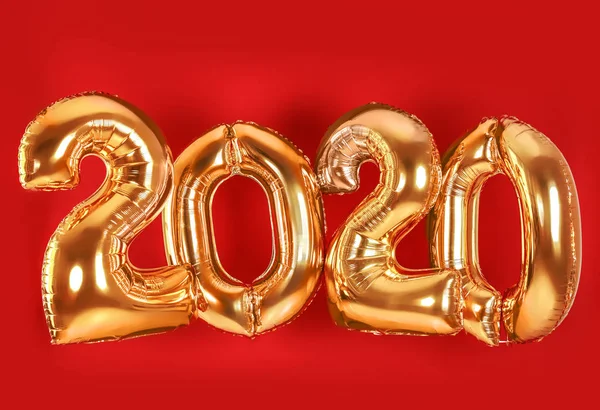 Palloncini d'oro per la decorazione del partito su sfondo rosso. 2020 Festeggiamenti di Capodanno — Foto Stock