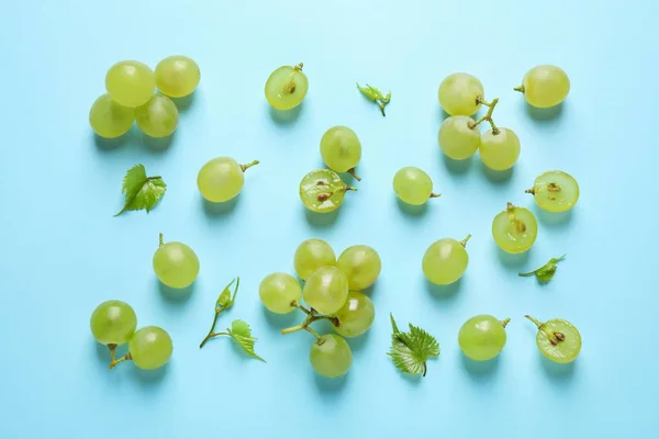 Platte lay compositie met verse rijpe sappige druiven op licht blauwe achtergrond — Stockfoto
