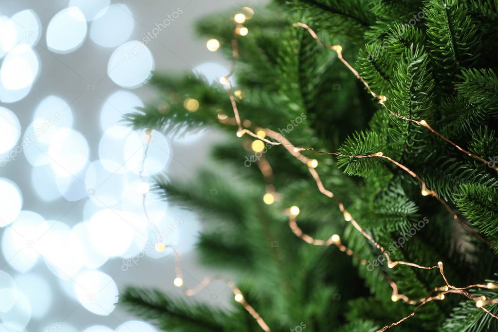 Decorated Christmas tree against blurred lights on background. Bokeh effect