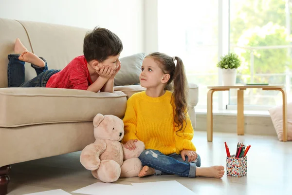 Schattige kleine jongen en meisje in de woonkamer — Stockfoto