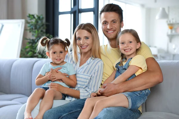 Lycklig familj med små barn på soffan i vardagsrummet — Stockfoto