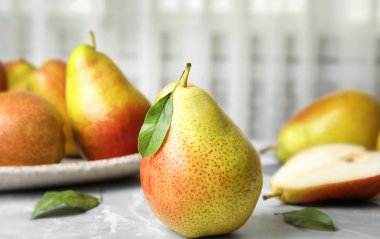 Açık arka plana karşı gri taş masada olgun sulu armutlar