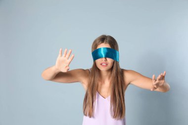 Gri arka planda açık mavi gözleri olan genç kadın