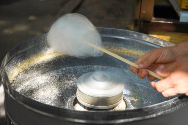 Modern makine açık havada kullanarak pamuk şeker yapma Adam, closeup