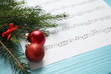 Mavi ahşap masa üzerinde Noel süslemeleri ve müzik sayfası, metin için alan