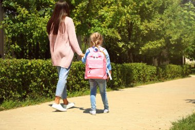 Genç anne park aracılığıyla okula küçük çocuğunu alarak