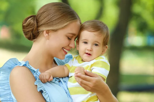 Hermosa madre con su lindo bebé en el parque en el día de verano — Foto de Stock