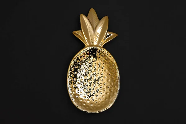Złota miska w kształcie ananasa na czarnym tle, widok z góry — Zdjęcie stockowe