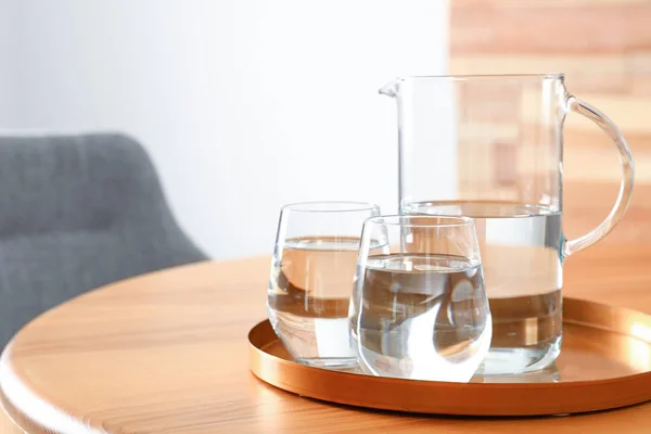 部屋の木製のテーブルの上に水のジャグとグラスとトレイ、テキストのためのスペース。さわやかな飲み物 — ストック写真