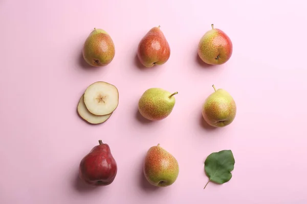 Peras maduras jugosas con hoja sobre fondo rosa, planas —  Fotos de Stock