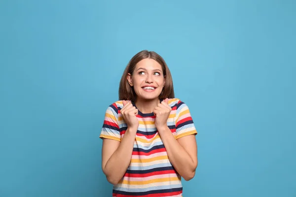Portret van emotionele jonge vrouw op licht blauwe achtergrond — Stockfoto