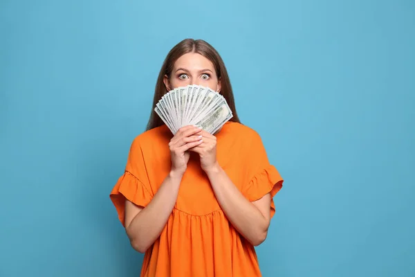 Retrato de feliz vencedor da loteria com ventilador de dinheiro no fundo azul claro — Fotografia de Stock