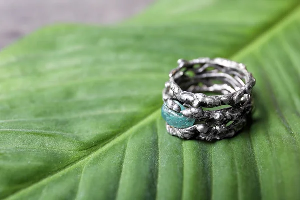 Belle bague en argent avec pierre précieuse apatite sur feuille verte. Espace pour le texte — Photo