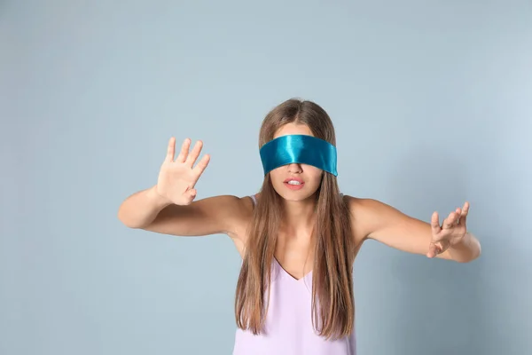 Jovem com luz azul venda sobre fundo cinza — Fotografia de Stock