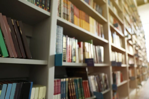 Blurred view of shelves with books in library — Stock Photo, Image