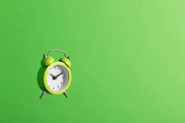 Relógio de alarme no fundo verde. Espaço para texto — Fotografia de Stock