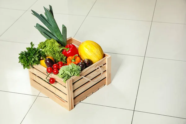 Holzkiste mit frischem Gemüse auf dem Boden. Raum für Text — Stockfoto