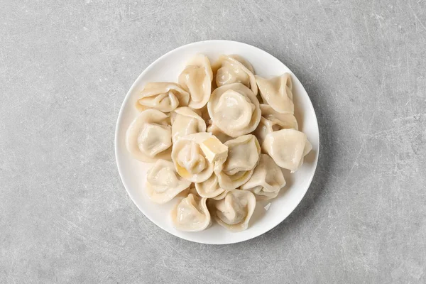 Läckra dumplings med smör på grått bord, uppifrån — Stockfoto