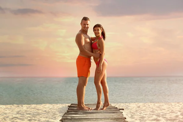 Mujer joven en bikini pasando tiempo con su novio en la playa. Hermosa pareja. —  Fotos de Stock