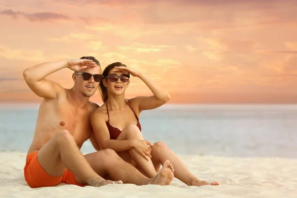 Mujer joven en bikini pasando tiempo con su novio en la playa. Hermosa pareja. —  Fotos de Stock