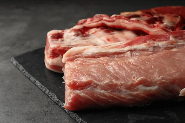 Placa de ardósia com carne crua na mesa cinza, close-up — Fotografia de Stock