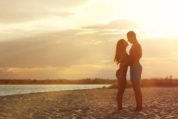 Mujer joven en bikini pasando tiempo con su novio en la playa. Hermosa pareja. — Foto de Stock