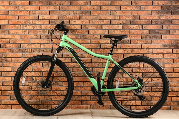 Vélo moderne près du mur de briques à l'intérieur. Mode de vie sain — Photo