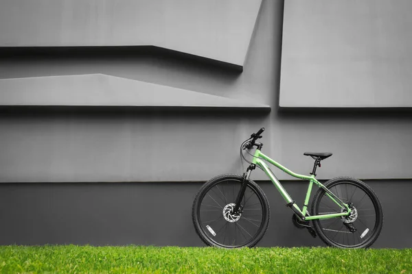 Nowa Nowoczesna kolorowa rower w pobliżu ciemnej szarej ściany na zewnątrz — Zdjęcie stockowe