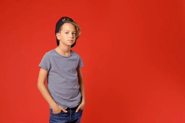 Cute little boy in casual outfit on red background. Space for text — Stockfoto