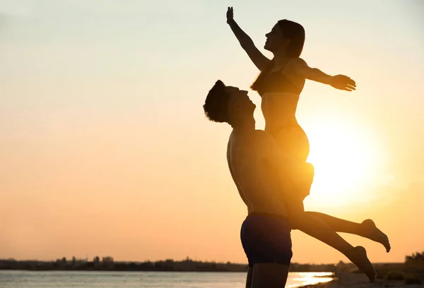 Junge Frau im Bikini verbringt Zeit mit ihrem Freund am Strand bei Sonnenuntergang. Liebes Paar — Stockfoto