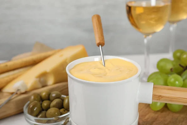 Kruka med välsmakande ostfondue och produkter på bordet — Stockfoto