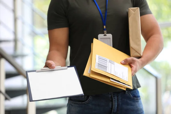 Ung kurir med paket och Urklipp inomhus, närbild. Leveransservice — Stockfoto