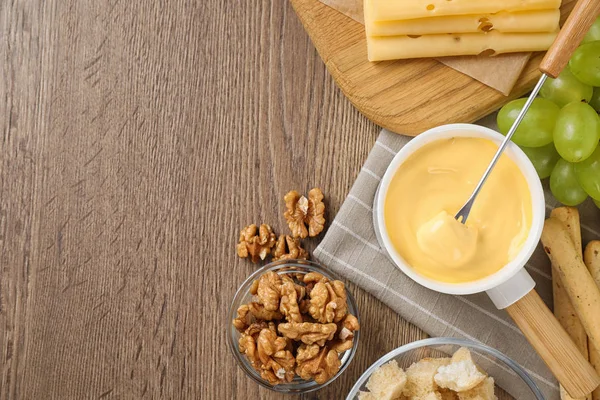 Composição de colocação plana com pote de fondue de queijo saboroso na mesa de madeira, espaço para texto — Fotografia de Stock