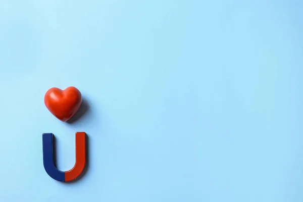 Hoefijzer magneet met hart op licht blauwe achtergrond, platte lag. Ruimte voor tekst — Stockfoto