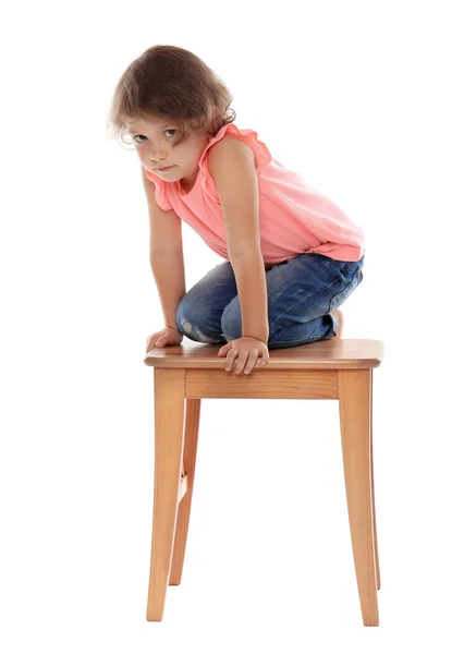 Little girl on stool against white background. Danger at home — Stock Photo, Image