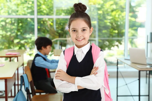 Dívka nosí školní uniformu s batohu ve třídě — Stock fotografie