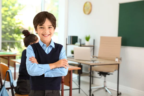 Pojke klädd i nya skoluniform i klassrummet — Stockfoto