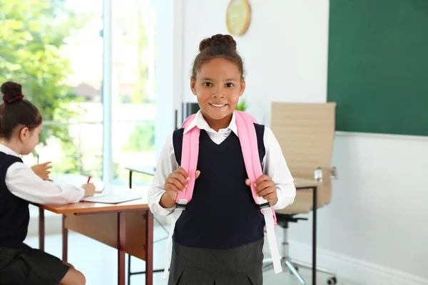 African-American girl wearing school uniform in classroom