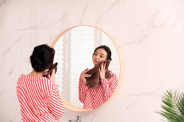 Молодая женщина с полотенцем возле зеркала в ванной комнате — стоковое фото