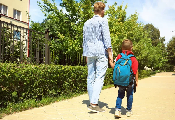 Junger Vater bringt sein kleines Kind durch Park zur Schule — Stockfoto