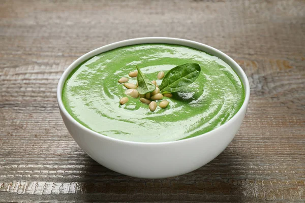 Tigela de sopa verde saudável com espinafre fresco na mesa de madeira — Fotografia de Stock