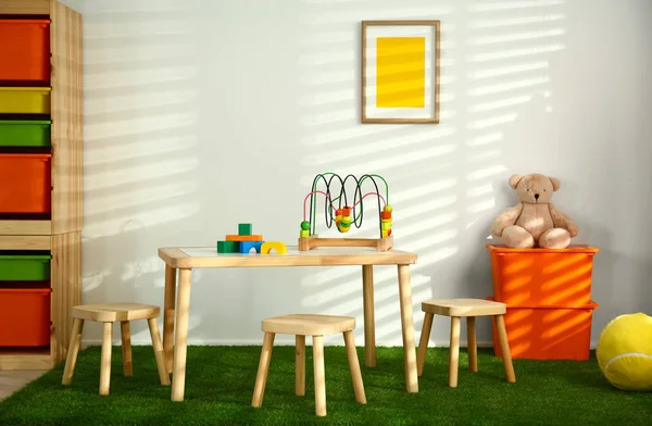 Стильный интерьер игровой комнаты с деревянным столом и стульями — стоковое фото