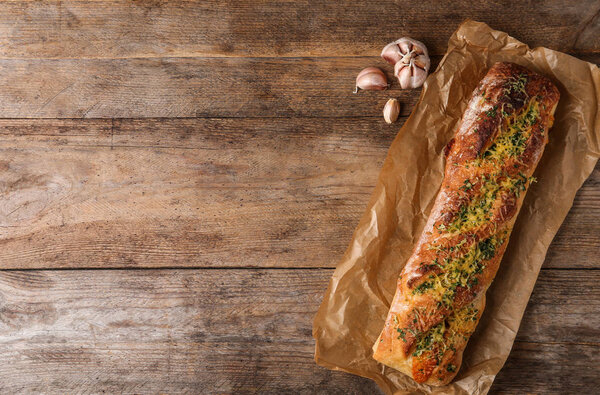 Вкусный домашний чесночный хлеб с сыром и травами на деревянном столе, плоский уголок. Пространство для текста
