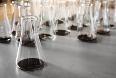 Gri masa üzerinde toprak örnekleri ile Cam. Laboratuvar araştırmaları