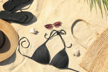 Kum üzerinde şık plaj aksesuarları ile düz döşeme kompozisyon